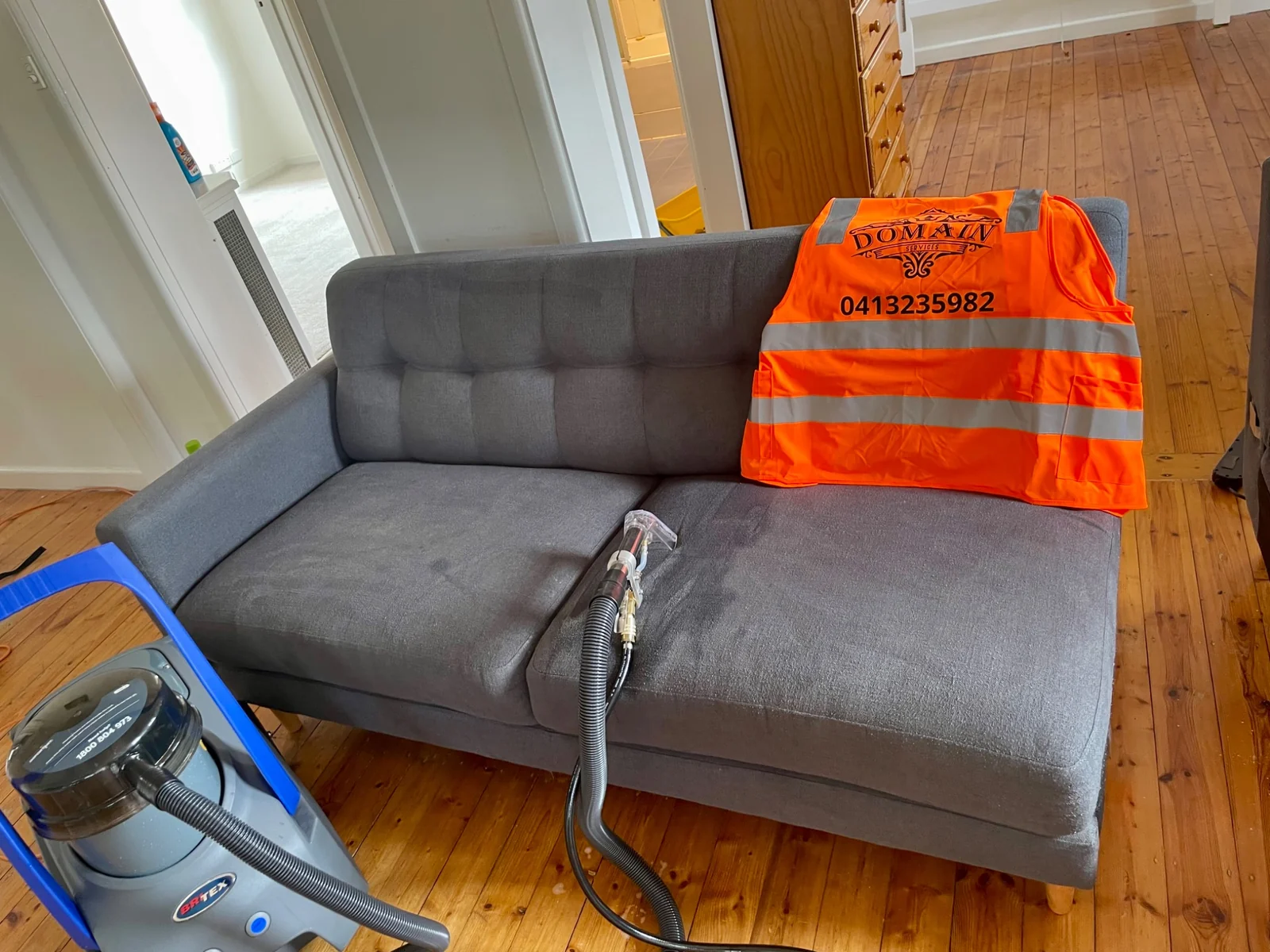 Domain Services CL sofa cleaning with branded safety vest and Britex machine